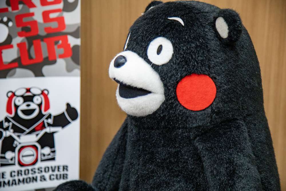 中国の看板の前にツキノワグマのぬいぐるみが立っています。 中国の看板の前にツキノワグマのぬいぐるみが立っています。