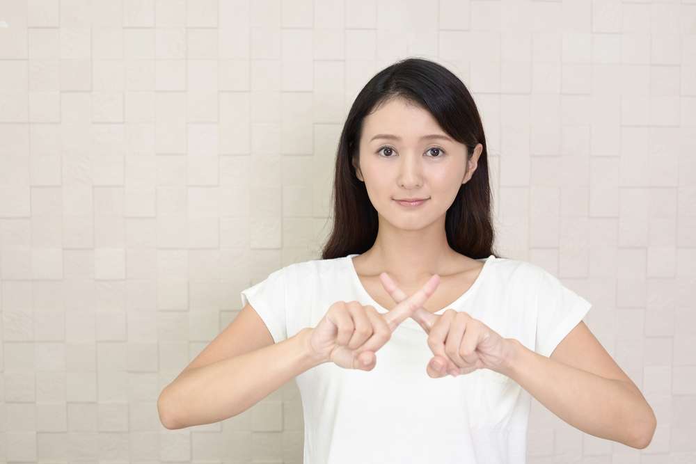 手でサインをする若い中国人女性。 手でサインをする若い中国人女性。