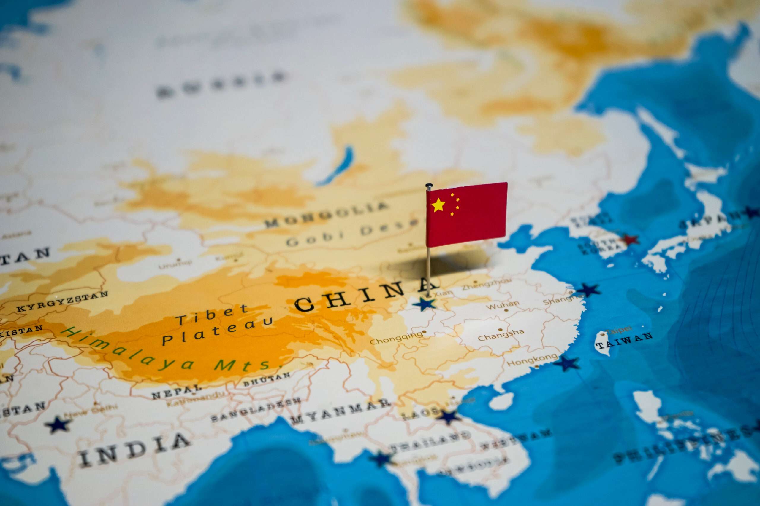 中国の地図上に国旗がピンで留められています。 中国の地図上に国旗がピンで留められています。