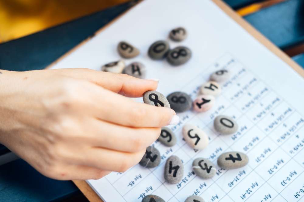 中国で石が乗ったクリップボードを持つ手。 中国で石が乗ったクリップボードを持つ手。