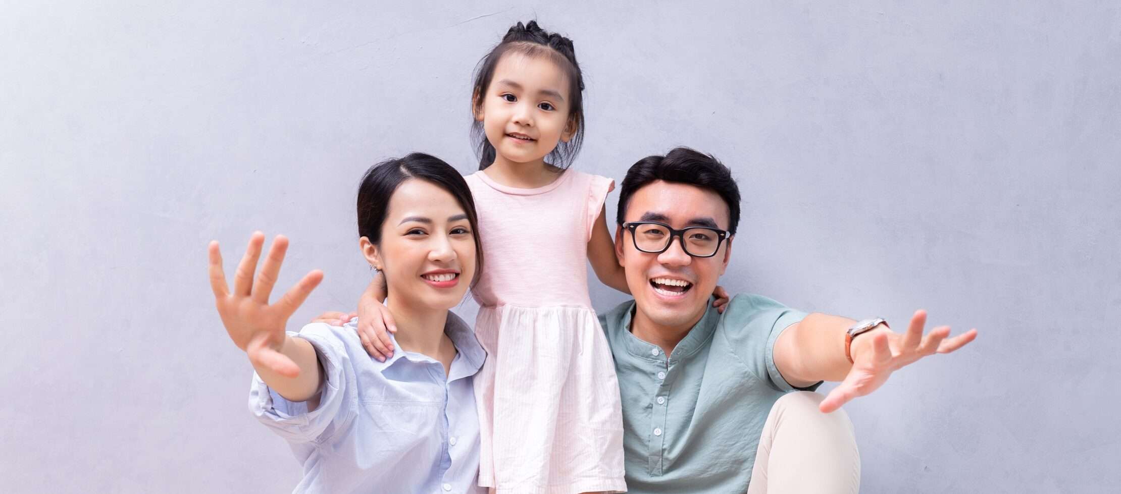 カメラに向かってポーズをとる小さな女の子を持つアジアの家族。