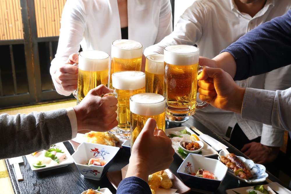 中国のテーブルでビールで乾杯する人々のグループ。 中国のテーブルでビールで乾杯する人々のグループ。