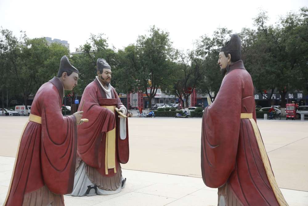 3 人の中国男性が紫色の長靴を着ている像。 3 人の中国男性が紫色の長靴を着ている像。
