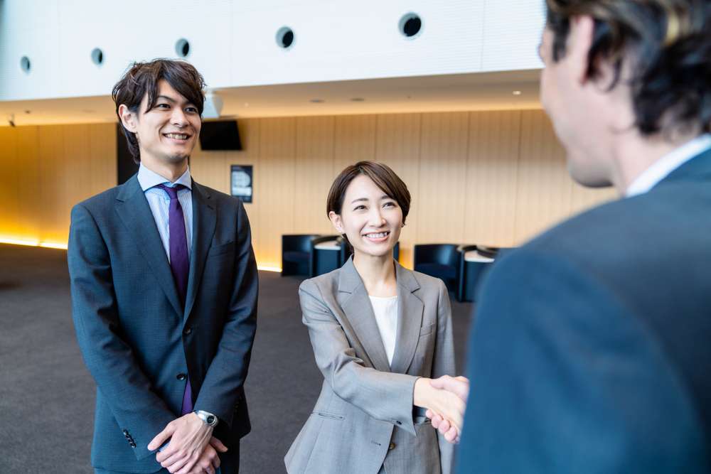 オフィスで握手する中国人ビジネスマンのグループ。 オフィスで握手する中国人ビジネスマンのグループ。