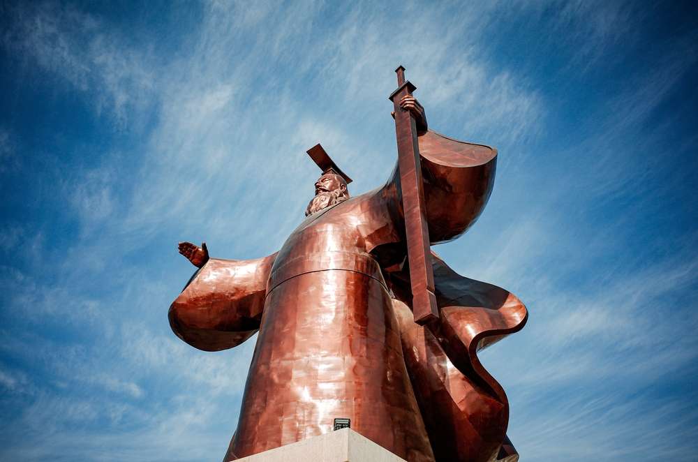 中国の青空の前でギターを抱えた男性の像。