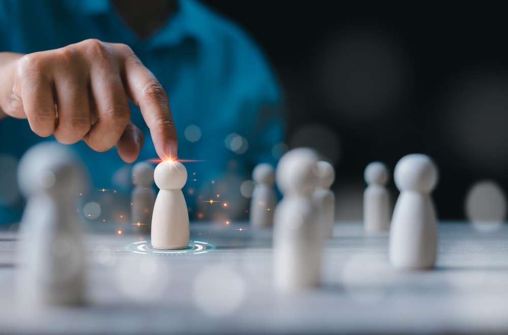 中国の伝統的な職人技を彷彿とさせるオーラを放つ、接触部分が光る木製駒のラインナップからフィギュアを選ぶ人。