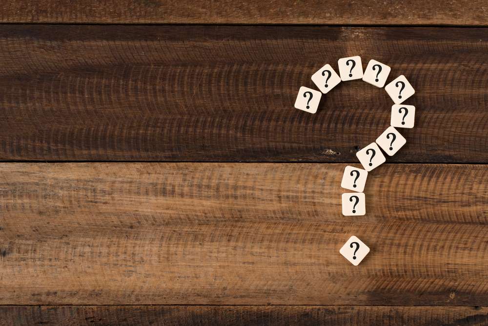 中国と刻まれた木の背景に白い疑問符のアイコンが疑問符の形に配置されます。 中国と刻まれた木の背景に白い疑問符のアイコンが疑問符の形に配置されます。