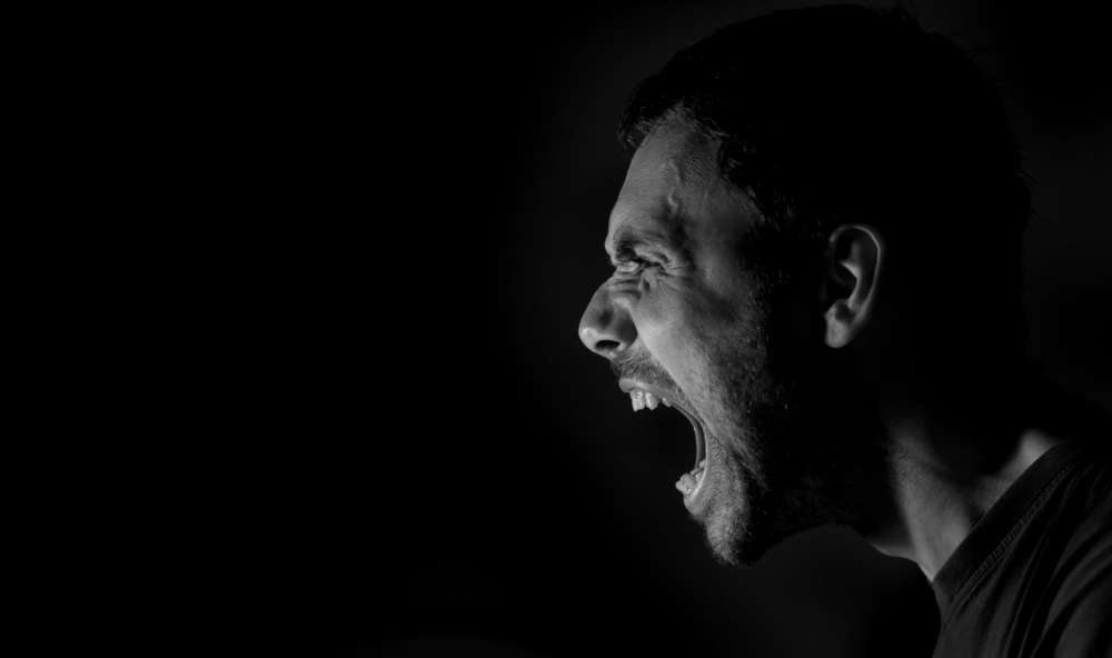 暗い背景に対して、口を大きく開けて叫んでいるように見える短髪の人物の横顔は、伝統的な中国の表現の生々しい激しさを想起させます。