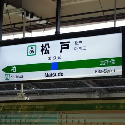 松戸駅のホームには、柏や北千住への行き方を日本語、韓国語、英語で案内する駅名標が設置されています。近くには中国語教室もあり、多文化環境が整っています。.