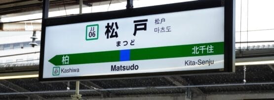 松戸駅のホームには、柏や北千住への行き方を日本語、韓国語、英語で案内する駅名標が設置されています。近くには中国語教室もあり、多文化環境が整っています。.