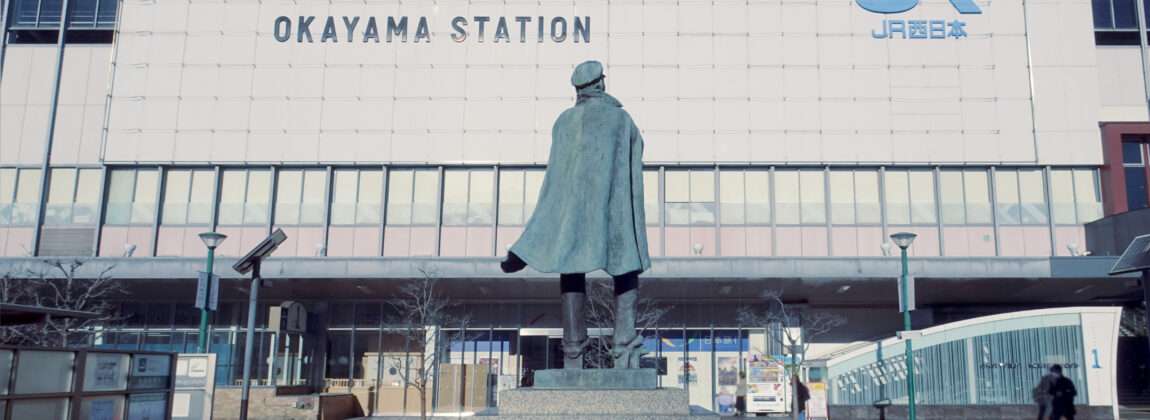 岡山駅前には青空をバックに堂々と立つブロンズ像が立ち、岡山・倉敷の風情を象徴する光景が広がっています。