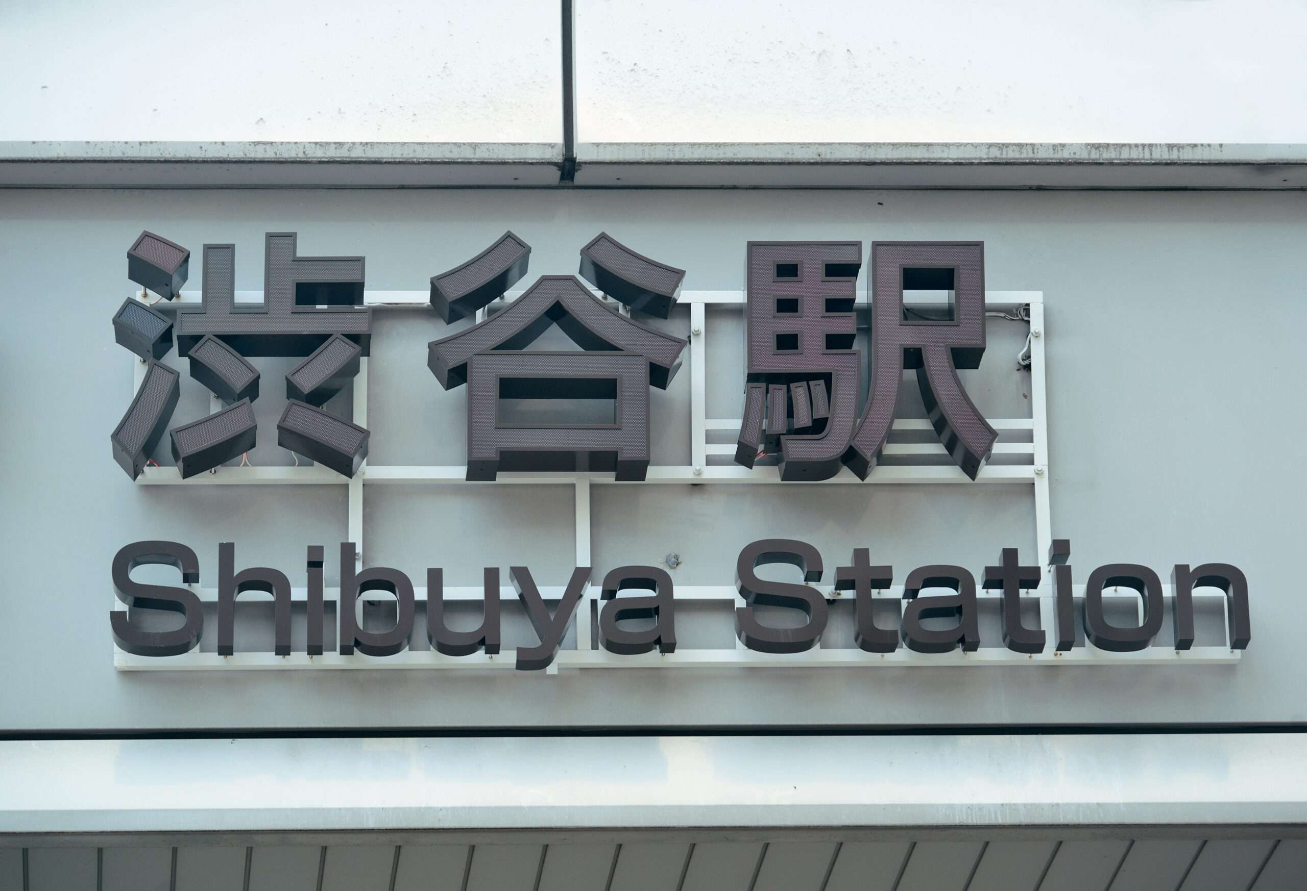 賑やかな中国語教室からそう遠くない建物に、上に日本語の文字で「渋谷駅」と書かれた標識が設置されている。