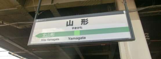 駅のホームには「山形」「北山形」と方向矢印が大きく書かれた標識が設置されている。近くには、山形・米沢エリアで受けられる中国語教室の広告が掲載されています。