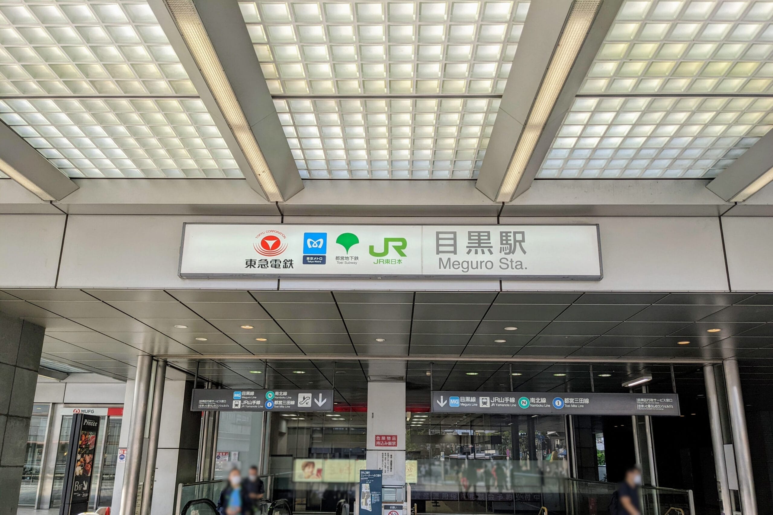 目黒駅の入り口には、天蓋の下にさまざまな交通機関のロゴと行き方を記した標識が設置されており、言語学習に興味がある人にとって中国語教室の近くに位置しています。.