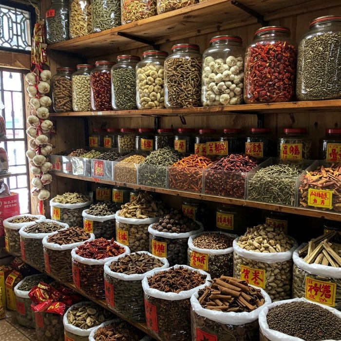 中国の市場で売られている大量のニンニク、八角、花椒などの香辛料