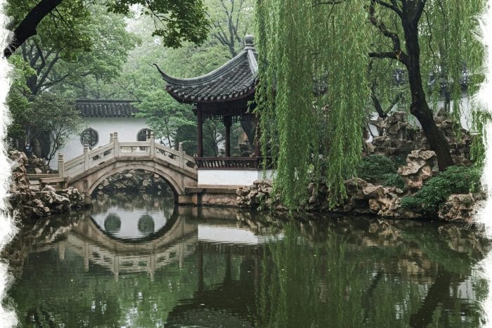 青い背景に微笑んで眼鏡を調整する女性。中国の美学を思い出させます。