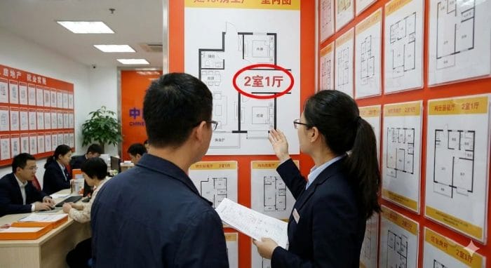 不動産屋で間取り図（2室1厅など）を見ている様子