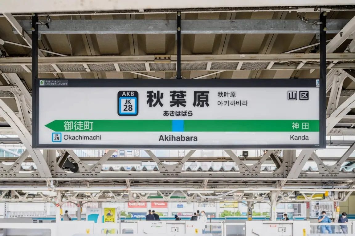東京の秋葉原駅ホームにある、日本語、英語、韓国語の駅名と最寄り駅の案内を表示した看板。.
