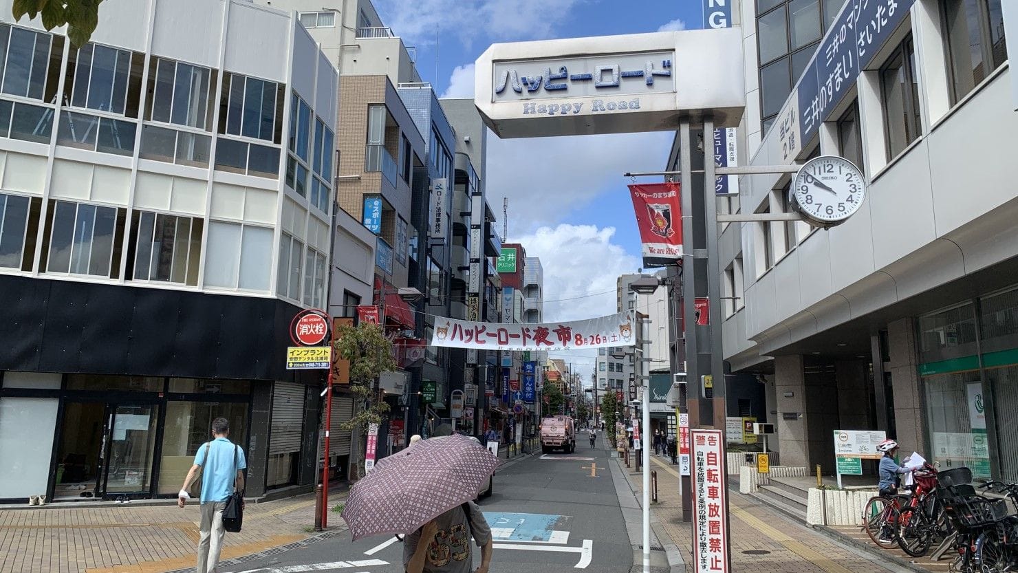 ハッピーロードのストリートビュー。建物、看板、人々。.